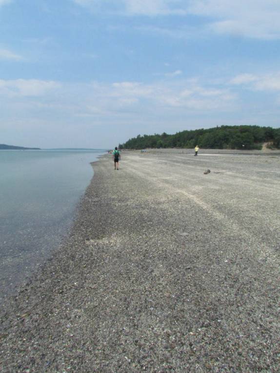 caminhando na ponte de areia formada na maré baixa, conectando Bar Harbor e a ilha em frente, em Maine, nos Estados Unidos